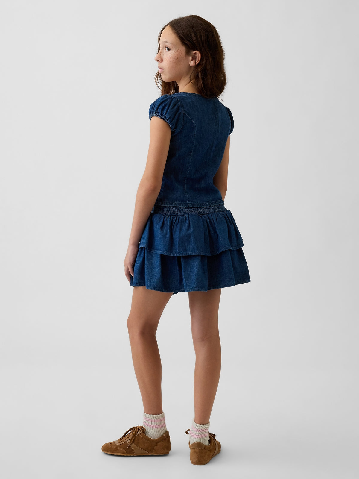Gap Kids Denim Smocked Mini Skort in Dark wash, back view on a child model