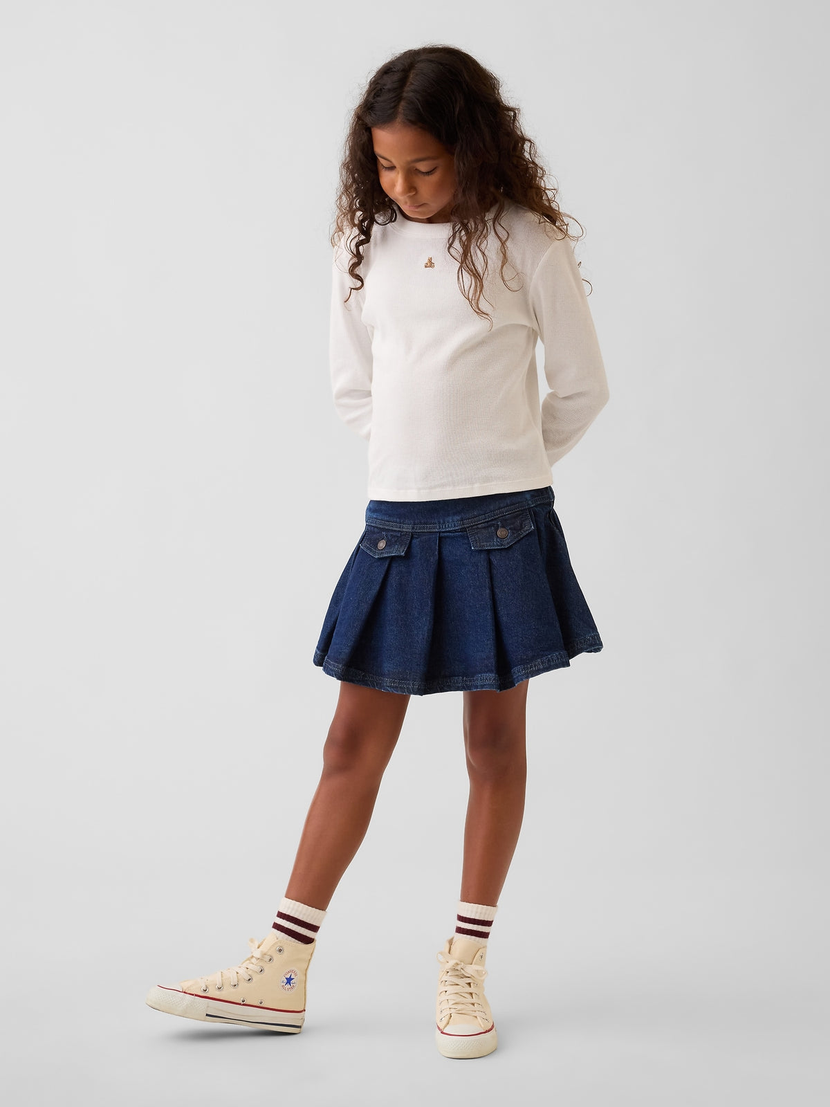 Gap Kids Denim Pleated Mini Skirt in Medium wash, full-length view on a child model